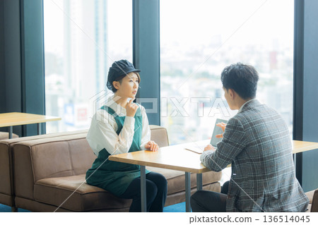 一位身穿空調西裝的男工匠正在開會，同時查看文件。 136514045
