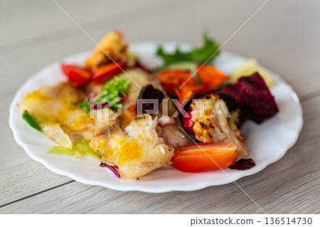 Baked fish fillet served with roasted vegetables on plate Baked fish fillet served with roasted vegetables on plate 136514730