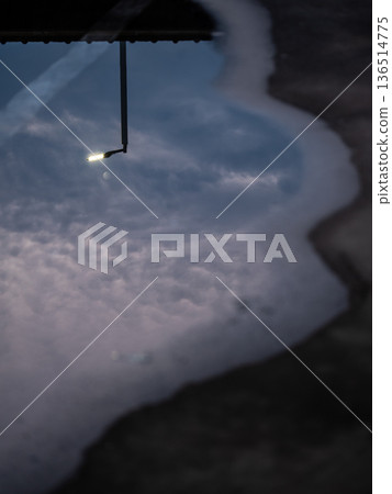 Reflection of street lights and sky on flood puddle on the road 136514775