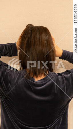 A woman holding her head in panic 136514969