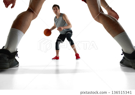 Basketball player dribbling while opponent guards from front isolated on white. Basketball player dribbling while opponent guards from front isolated on white. 136515341