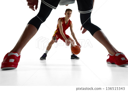 Creative perspective basketball player framed by opponent legs isolated on white background. Creative perspective basketball player framed by opponent legs isolated on white background. 136515343