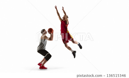 Basketball player attempting layup while defender jumps to block isolated on white background 136515346