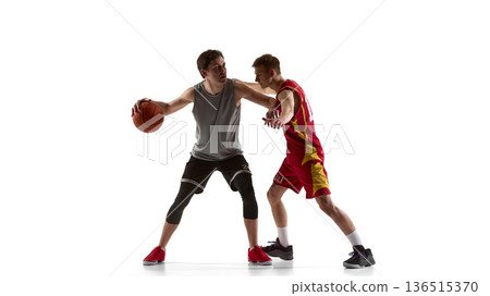 Basketball player protecting ball under defensive pressure isolated on white background. 136515370