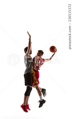Basketball player shooting while defender attempts block isolated on white background. 136515372