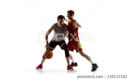 Basketball player blocking opponent while protecting ball in studio. Basketball player blocking opponent while protecting ball in studio. 136515382