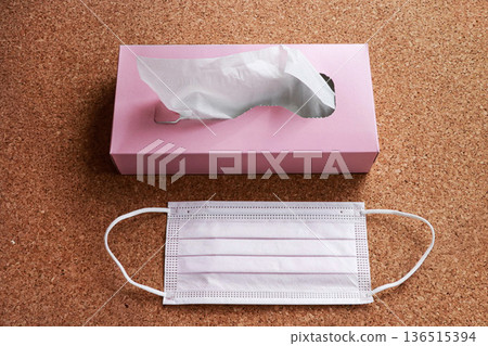 口罩和紙巾擺放在軟木背景上，展現自然健康照護概念。 136515394