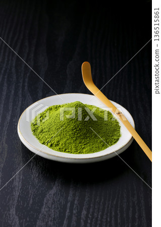 Vibrant green matcha powder stands out against a black wood grain background Vibrant green matcha powder stands out against a black wood grain background 136515861