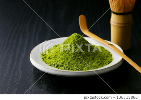鮮豔的綠色抹茶粉在黑色木紋背景的襯托下格外醒目。 鮮豔的綠色抹茶粉在黑色木紋背景的襯托下格外醒目。 136515866