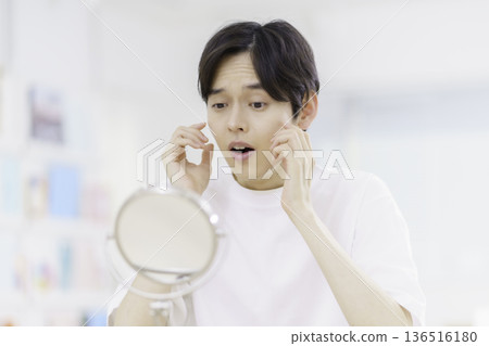 Men's Beauty: A young Japanese man is shocked by his rough skin when he looks in the mirror Men's Beauty: A young Japanese man is shocked by his rough skin when he looks in the mirror 136516180