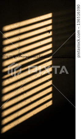 Sunlight Rays Through Blinds Casting Shadows on Dark Wall Sunlight Rays Through Blinds Casting Shadows on Dark Wall 136516390