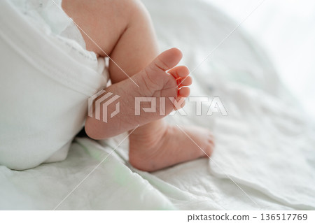 Close-up of baby feet in diaper on soft white blanket. Infant care, tenderness, early childhood concept 136517769