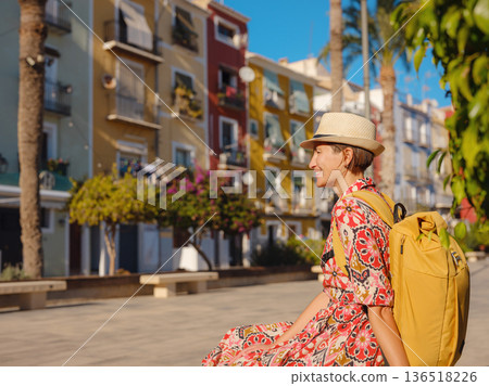 Woman strolls through colorful streets of Spanish coastal town 136518226