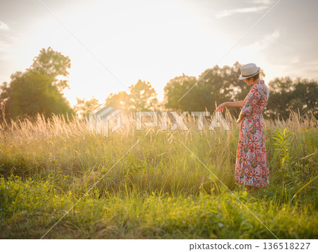 boho chic woman in a floral dress in European countryside 136518227