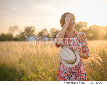 boho chic woman in a floral dress in European countryside boho chic woman in a floral dress in European countryside 136518228