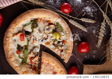 tasty fresh  Pizza served at  wooden table with cherry tomatos and wheat ears.  flat lay. 136518655