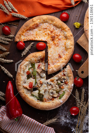 assortiment of tasty fresh Pizza. served at wooden table with cherry tomatos and wheat ears. flat lay. assortiment of tasty fresh Pizza. served at wooden table with cherry tomatos and wheat ears. flat lay. 136518661