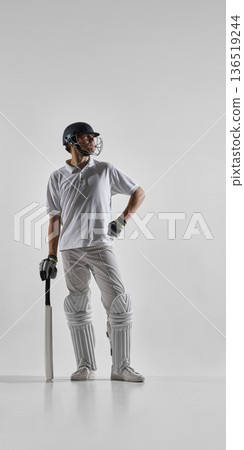 Cricket batsman standing with bat ready isolated on white background. Cricket batsman standing with bat ready isolated on white background. 136519244
