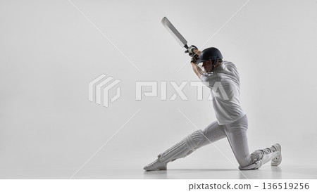 Cricket batsman preparing for defensive stroke isolated on white background. Cricket batsman preparing for defensive stroke isolated on white background. 136519256