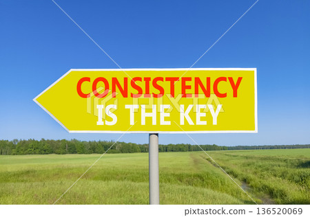Consistency is the key symbol. Concept words Consistency is the key on beautiful yellow road sign. Beautiful blue sky green field background. Business consistency is the key concept. Copy space. 136520069
