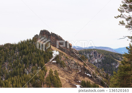 Mountain landscape with a rocky ridge and pine forest. Nature photography for travel and adventure themes. Spring season. Takmak rock, Stolby Krasnoyarsk Mountain landscape with a rocky ridge and pine forest. Nature photography for travel and adventure themes. Spring season. Takmak rock, Stolby Krasnoyarsk 136520163