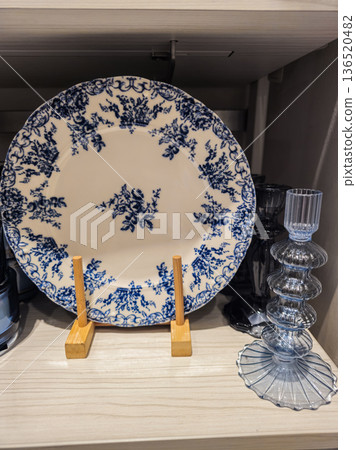 Blue and White Patterned Plates with Glass Candle Holder on Shelf Blue and White Patterned Plates with Glass Candle Holder on Shelf 136520482