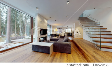A spacious living room with wooden floors and large windows overlooking a beautiful forest in a private house. 136520570