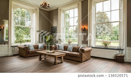 A spacious living room with wooden floors and large windows overlooking a beautiful forest in a private house. A spacious living room with wooden floors and large windows overlooking a beautiful forest in a private house. 136520571