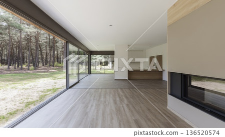A spacious ground-floor living room with mixed wood and laminate flooring and large windows facing a forest. A spacious ground-floor living room with mixed wood and laminate flooring and large windows facing a forest. 136520574