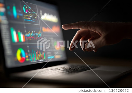 Close-up of a hand pointing at analytical graphs and detailed data on a laptop screen during a business meeting. Close-up of a hand pointing at analytical graphs and detailed data on a laptop screen during a business meeting. 136520652