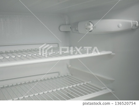 Clean empty fridge interior with adjustable thermostat dial and wire shelves. White modern refrigerator inside view, cold storage concept, minimal kitchen appliance background Clean empty fridge interior with adjustable thermostat dial and wire shelves. White modern refrigerator inside view, cold storage concept, minimal kitchen appliance background 136520754