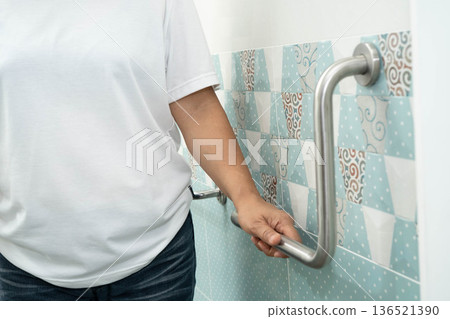Asian woman patient use toilet support rail in bathroom, handrail safety grab bar, security in nursing hospital. Asian woman patient use toilet support rail in bathroom, handrail safety grab bar, security in nursing hospital. 136521390