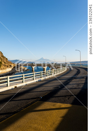 The viaduct over the sea at Okuzure Coast and Mount Fuji over Suruga Bay, shining on a clear winter day 136522041