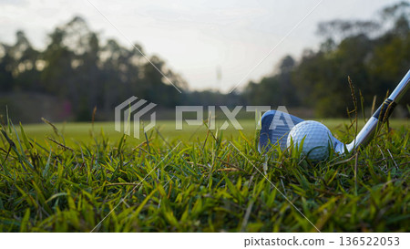 Golf clubs and balls on a green lawn in a beautiful golf course with morning sunshine. 136522053