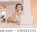 Business woman talking on a smartphone in the office 136522131