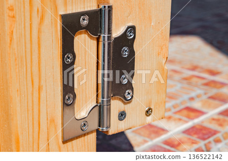 metal hinge on wooden gate, close-up metal hinge on wooden gate, close-up 136522142
