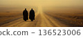 Two figures walking on foggy desert path at sunrise 136523006