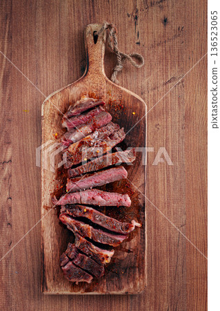medium rare, sliced rib eye steak, grilled cowboy steak, on a chopping board, close-up, homemade, top view, no people, 136523065