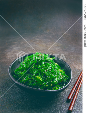 Chuka salad, made from fresh seaweed, with sesame dressing, served in a black bowl, with chopsticks, 136523079