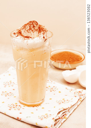 eggnog drink, egg yolk, in a glass, with cream and cinnamon, sunlight, 136523082