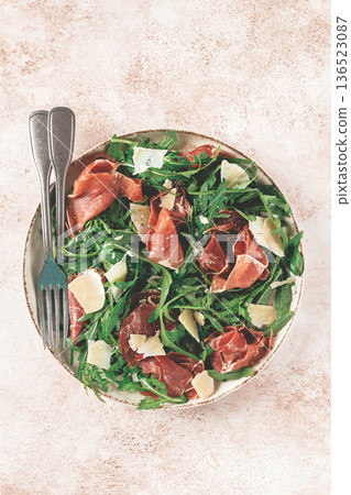 Fresh arugula salad with prosciutto and grated parmesan cheese, on a plate, homemade, no people, 136523087