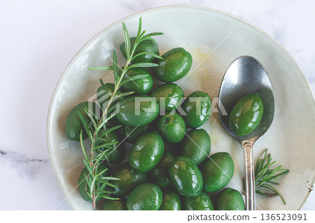 Chalkidiki olives, classic Greek green olive, on a plate, with a spoon, top view, no people, Chalkidiki olives, classic Greek green olive, on a plate, with a spoon, top view, no people, 136523091