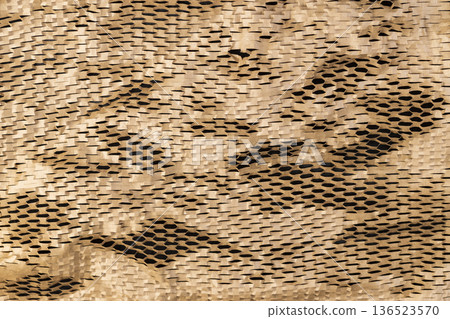 crumpled yellow paper with a lot of cuts is used for packaging and decorative purposes, closeup crumpled yellow paper with a lot of cuts is used for packaging and decorative purposes, closeup 136523570
