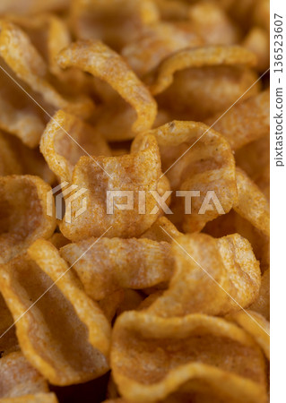 crispy mashed potato chips fried in a large amount of oil, sprinkled with red hot pepper spices, crispy delicious high-calorie chips with spices are scattered on the table crispy mashed potato chips fried in a large amount of oil, sprinkled with red hot pepper spices, crispy delicious high-calorie chips with spices are scattered on the table 136523607