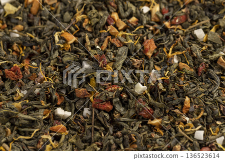 a large amount of dried green tea with the addition of natural flavors and pieces of fruits and berries, green tea with the addition of taste and smell of other sweet foods 136523614