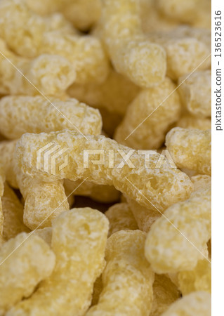 yellow large sweet sticks of corn with added sugar for quick cooking with milk or yogurt, ready-to-eat corn sticks scattered on food paper yellow large sweet sticks of corn with added sugar for quick cooking with milk or yogurt, ready-to-eat corn sticks scattered on food paper 136523616