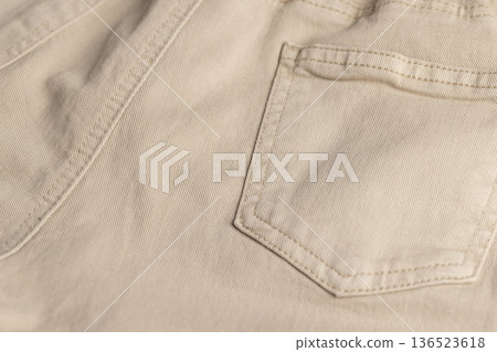 details of the beige fabric from which trousers or other clothes are sewn, close up details of the beige fabric from which trousers or other clothes are sewn, close up 136523618