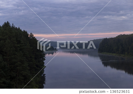 a wide river in the summer and trees on the shore during sunset with a sky, a landscape on the river at dusk with a multicolored sky that is reflected in the water of the river a wide river in the summer and trees on the shore during sunset with a sky, a landscape on the river at dusk with a multicolored sky that is reflected in the water of the river 136523631
