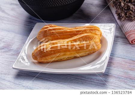 Sweet baked eclair dessert with cream 136523784