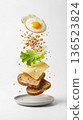 Infographic image of a layered breakfast, with toast, cheese, lettuce, rolled oats, and fried egg. Healthy meal concept 136523824